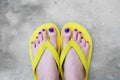 Yellow Sandals. Selfie WomanÃ¢â¬â¢s Sandals Feet with Violet Nail Pedicure of Paint on Cement Background